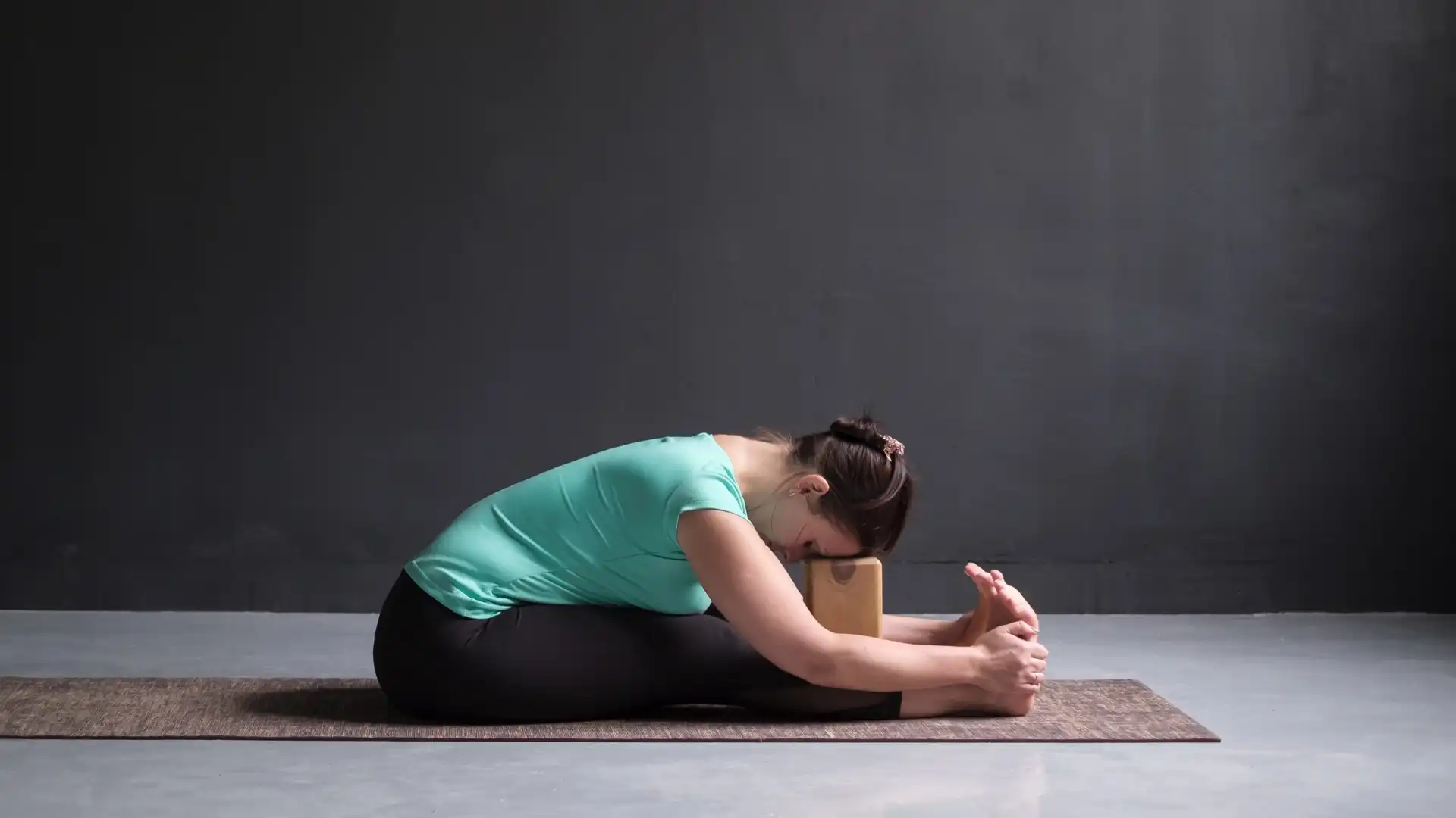 yoga_instructor_demonstrating_how_to_practice_seated_forward_bend_in_yoga_at_home