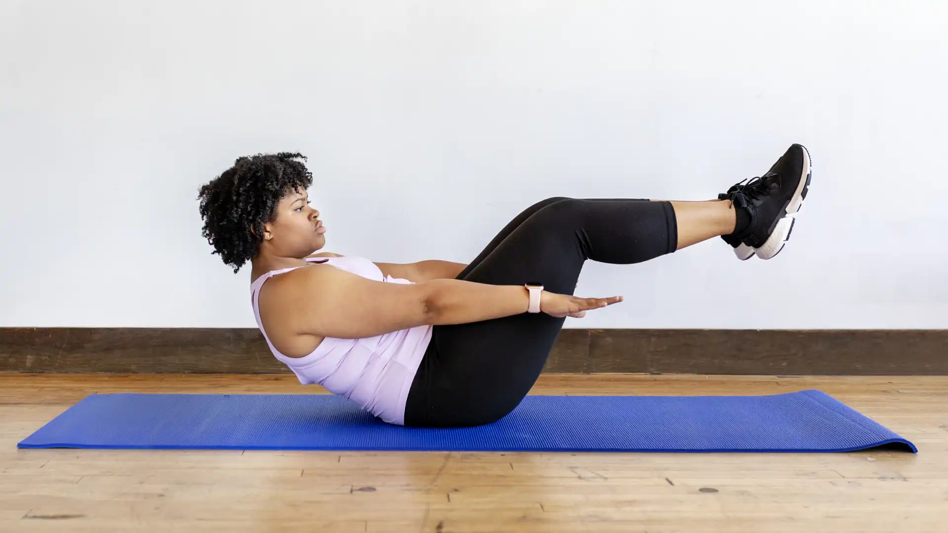 beginner_yoga_student_learning_how_to_practice_boat_pose_in_yoga_at_home