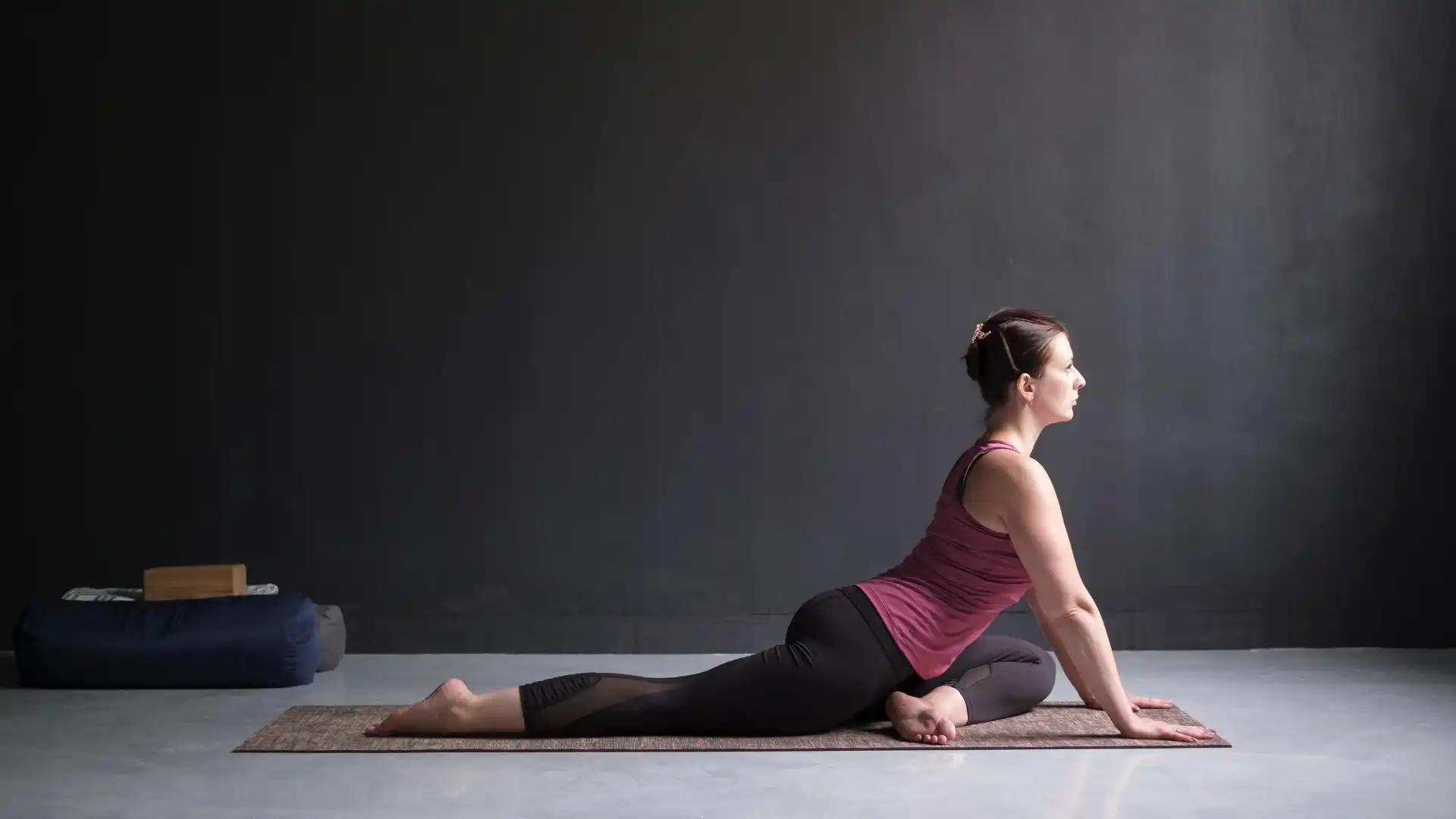 Beginner Yoga Student Demonstrating How to Practice a Modification of Pigeon Pose (Sanskrit Name: Kapotasana)