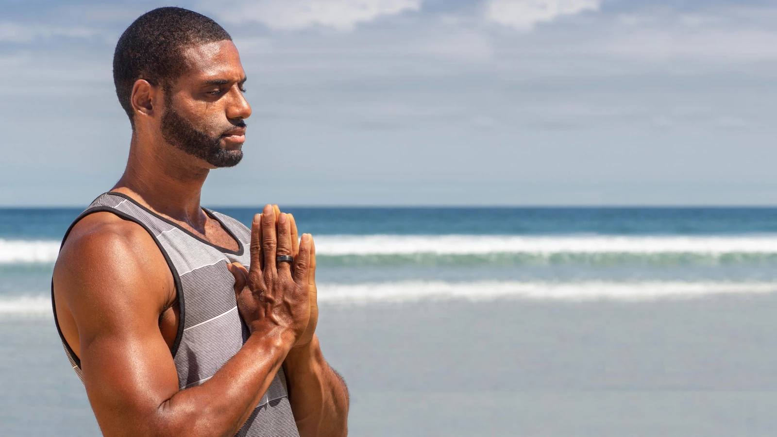 tips to practice yoga for stress and brain health man on beach in Anjali Mudra prayer position