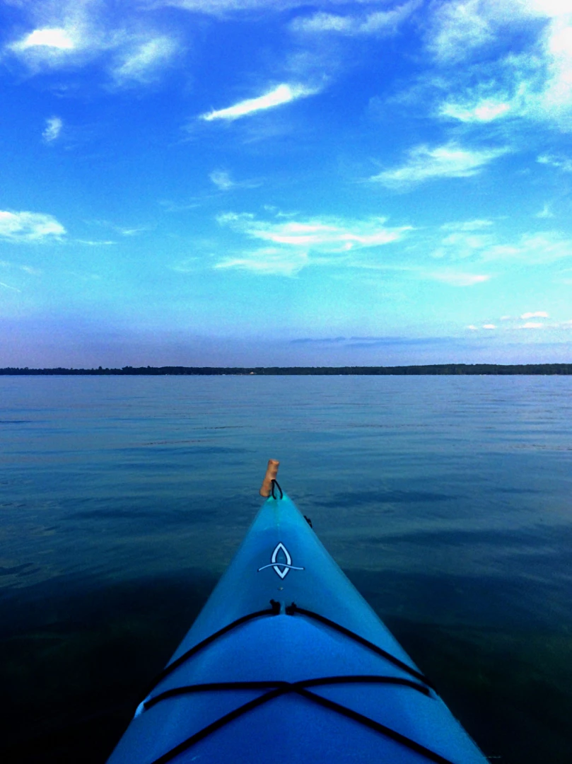 Yakak boat on beautiful lake water looking at the sunset on the horizon