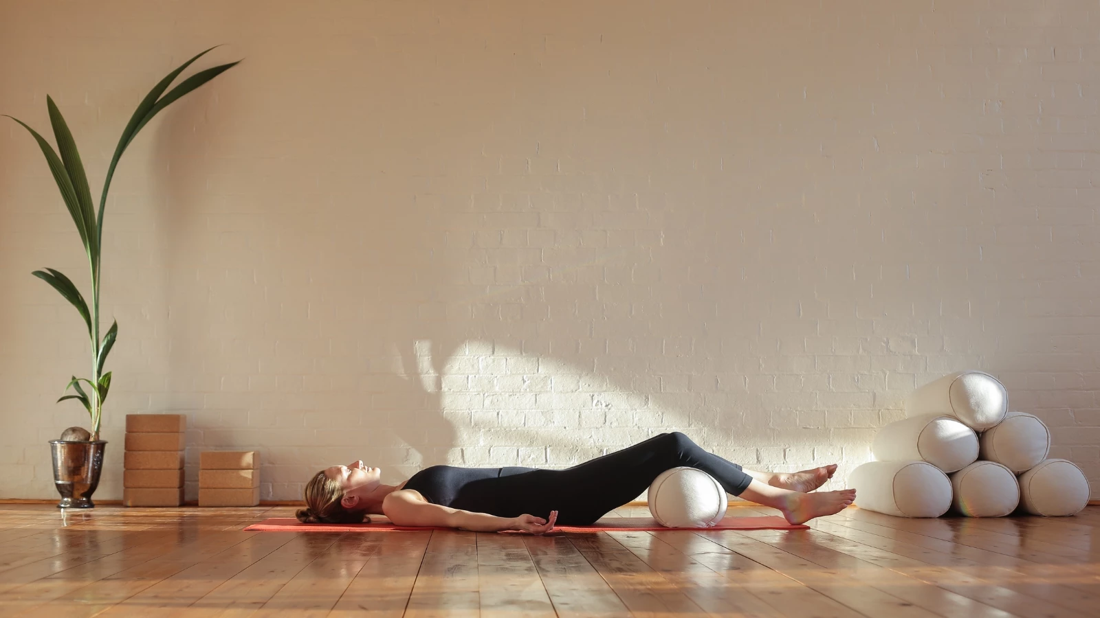 Beginner yoga tips to practice Corpse Pose (Savasana) with bolster in a mindful way