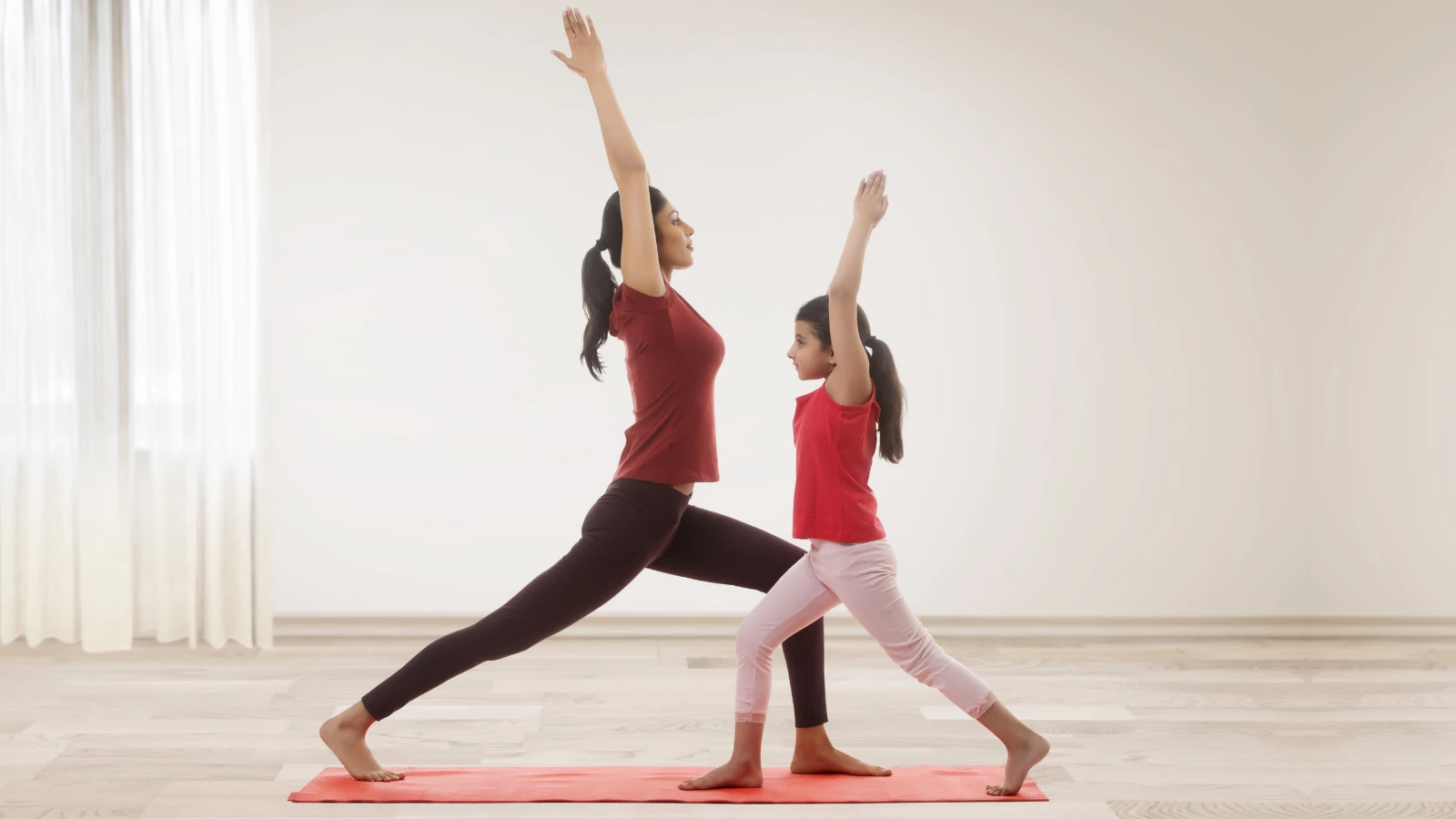 Yoga teacher and child practicing yoga and experiencing the benefits of eating nutritious food