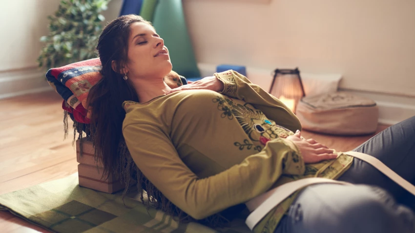 Serene lady relaxing and meditating as preparation for a great night's sleep