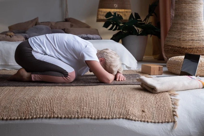 older woman practicing child's pose for calming Vata Dosha for better mental health