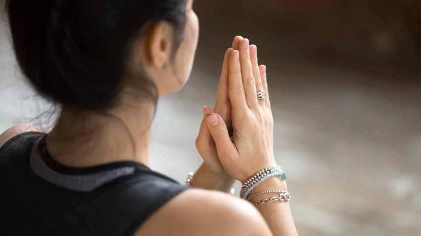 Namaste gesture close up photo, woman practice yoga representing the opening of the heart chakra