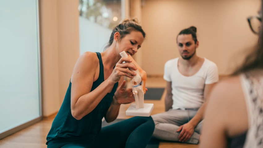 Yoga Teacher using anatomy props to help students have a better understanding of the body and yoga