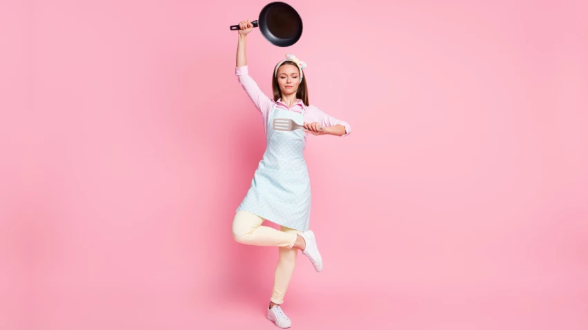 Yogini in kitchen holding kitchenware utensil posing meditating, and yoga asana