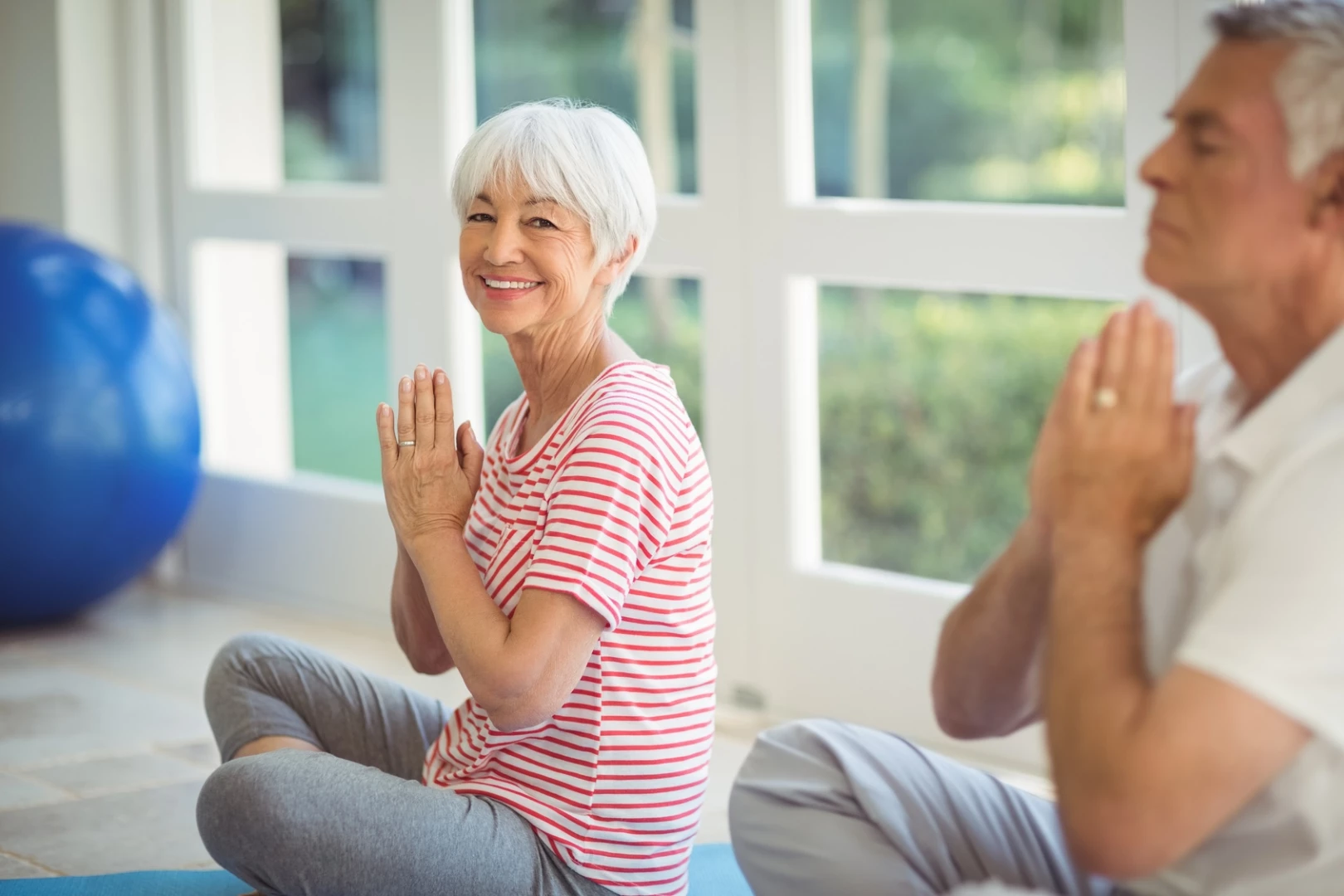 older woman practicing yoga for posture improvment and yoga for hyperyphosis