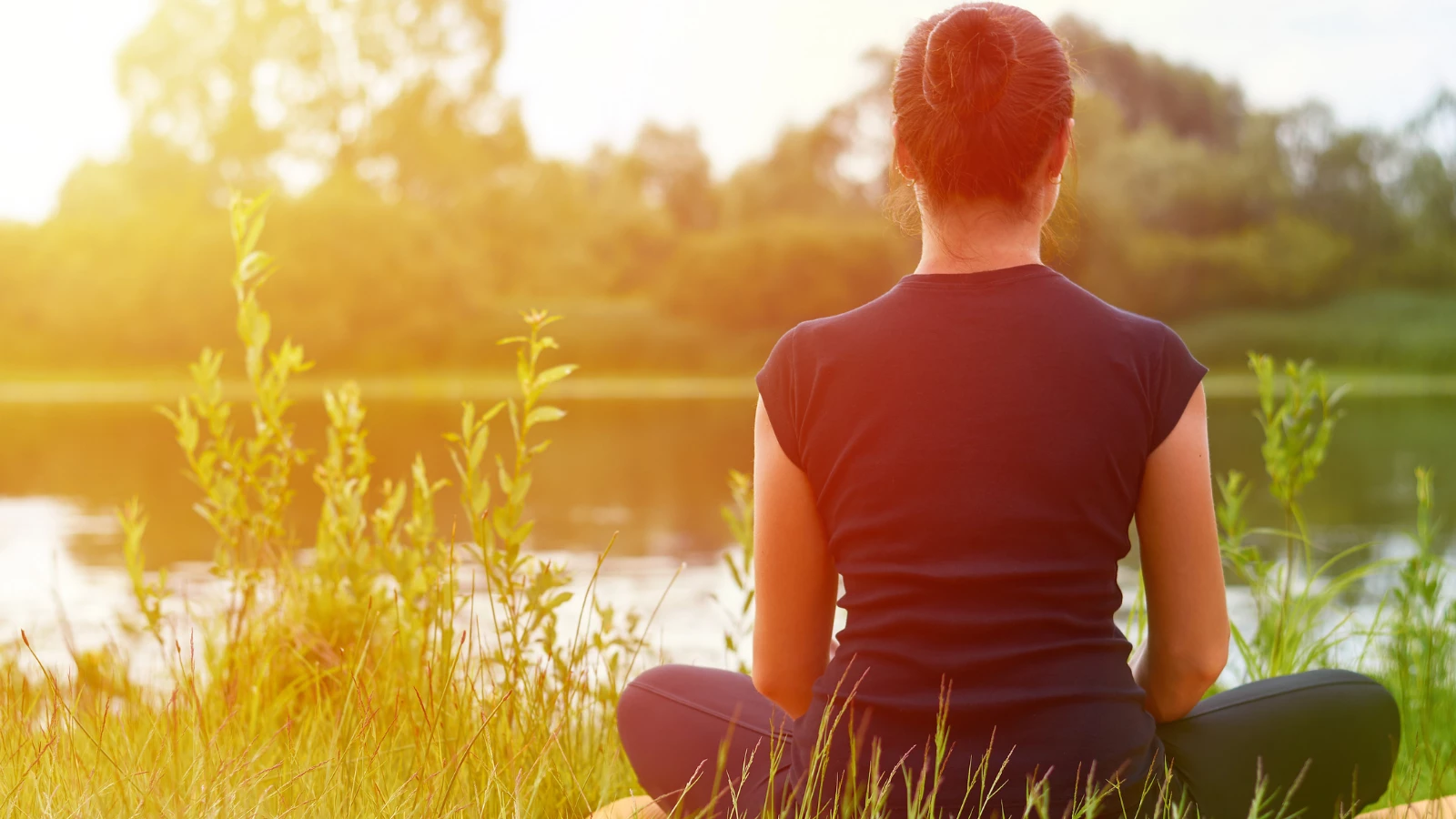 Young girl practices yoga on the shore of the River, concept of enjoying privacy and concentration