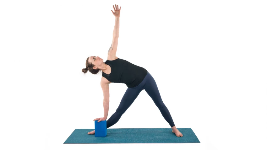 Triangle Pose or Trikonasana is a strengthening and lengthening pose