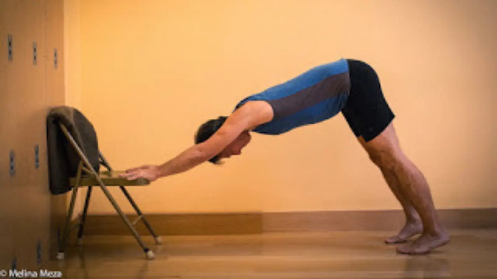 A gentle version of Downward Facing Dog Pose with hands on a chair instead of the floor. 