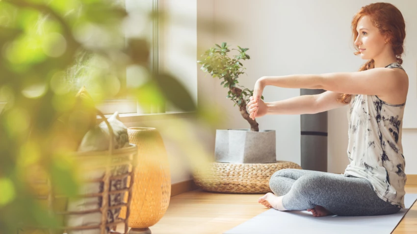 Woman stretching her hands, and taking care of her wrists-warming-up for yoga class