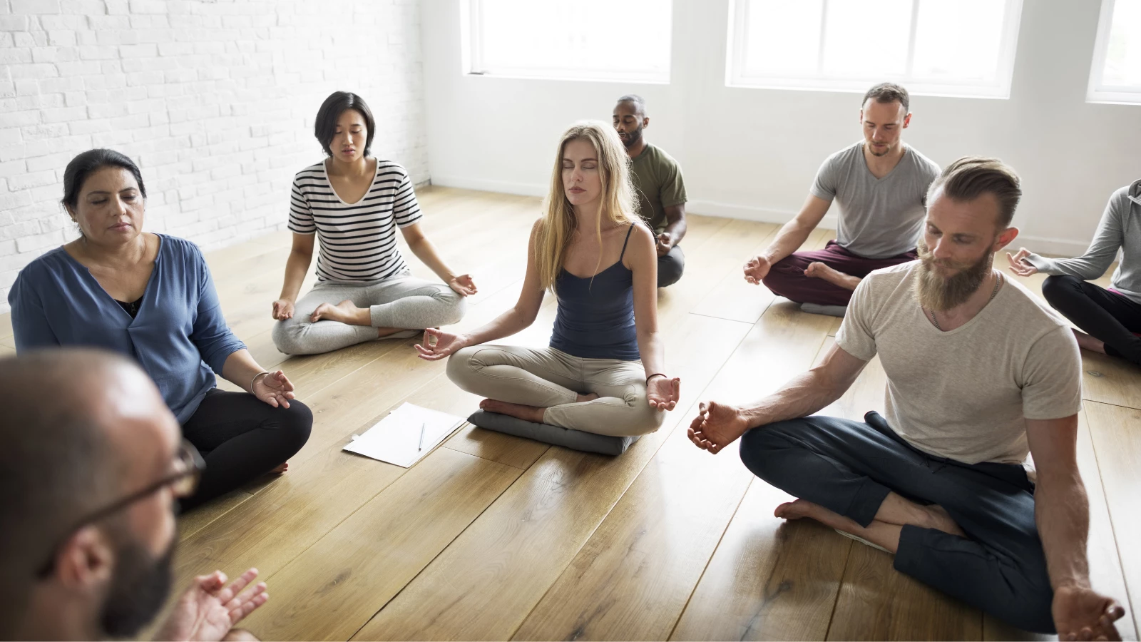 Diverse students with teacher in Yoga Class