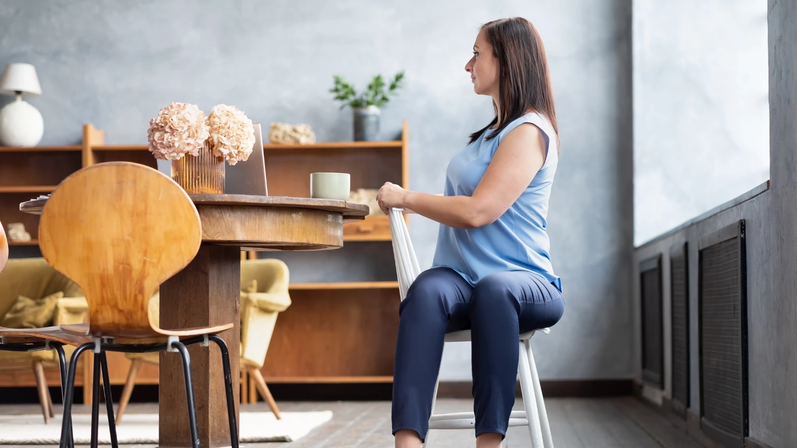 Female office worker in yoga pose Ardha Matsyendrasana or Half Lord of the Fishes Pose on a chair