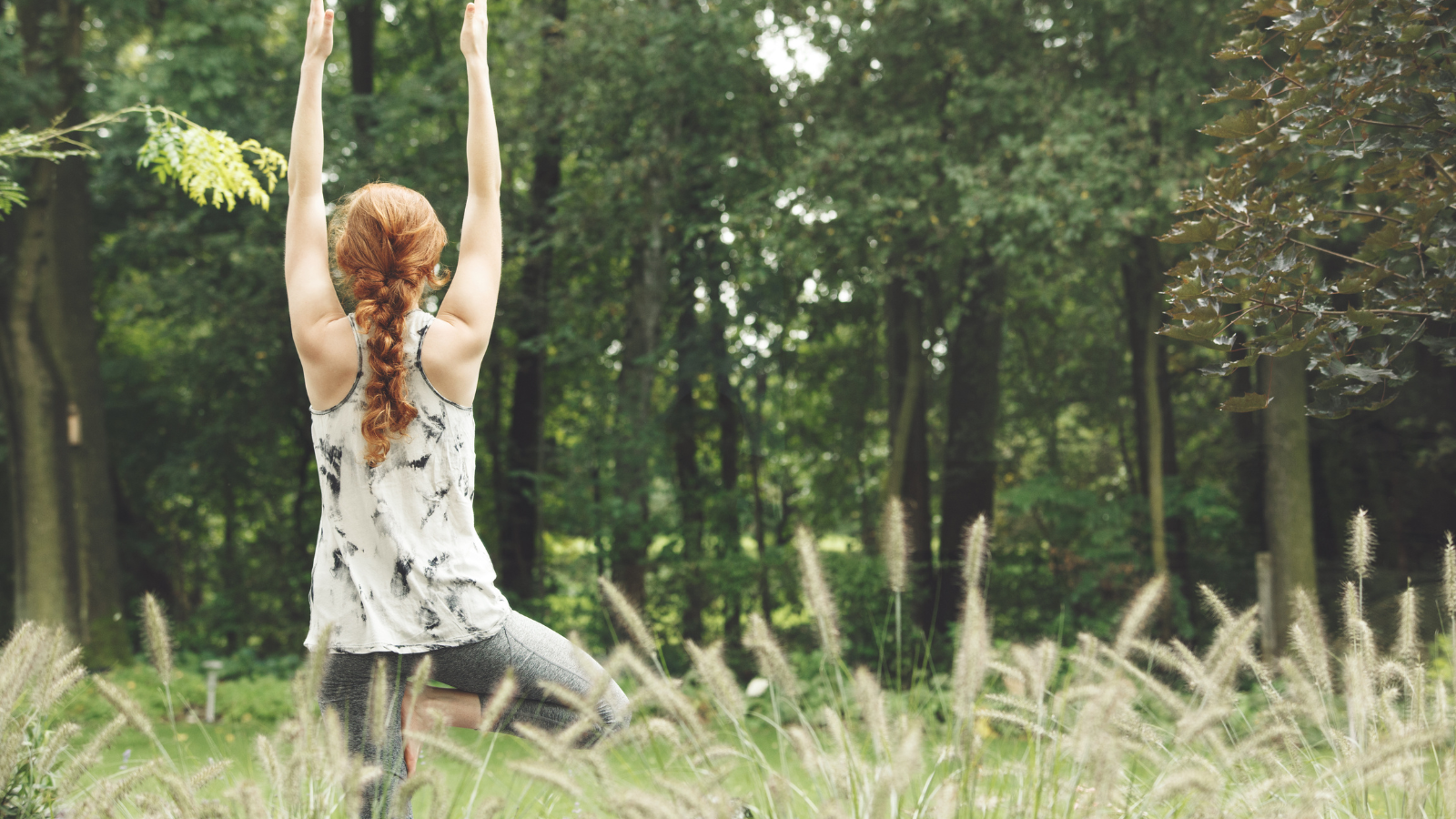 Young woman in Vrksasana yoga pose also known as Tree Pose