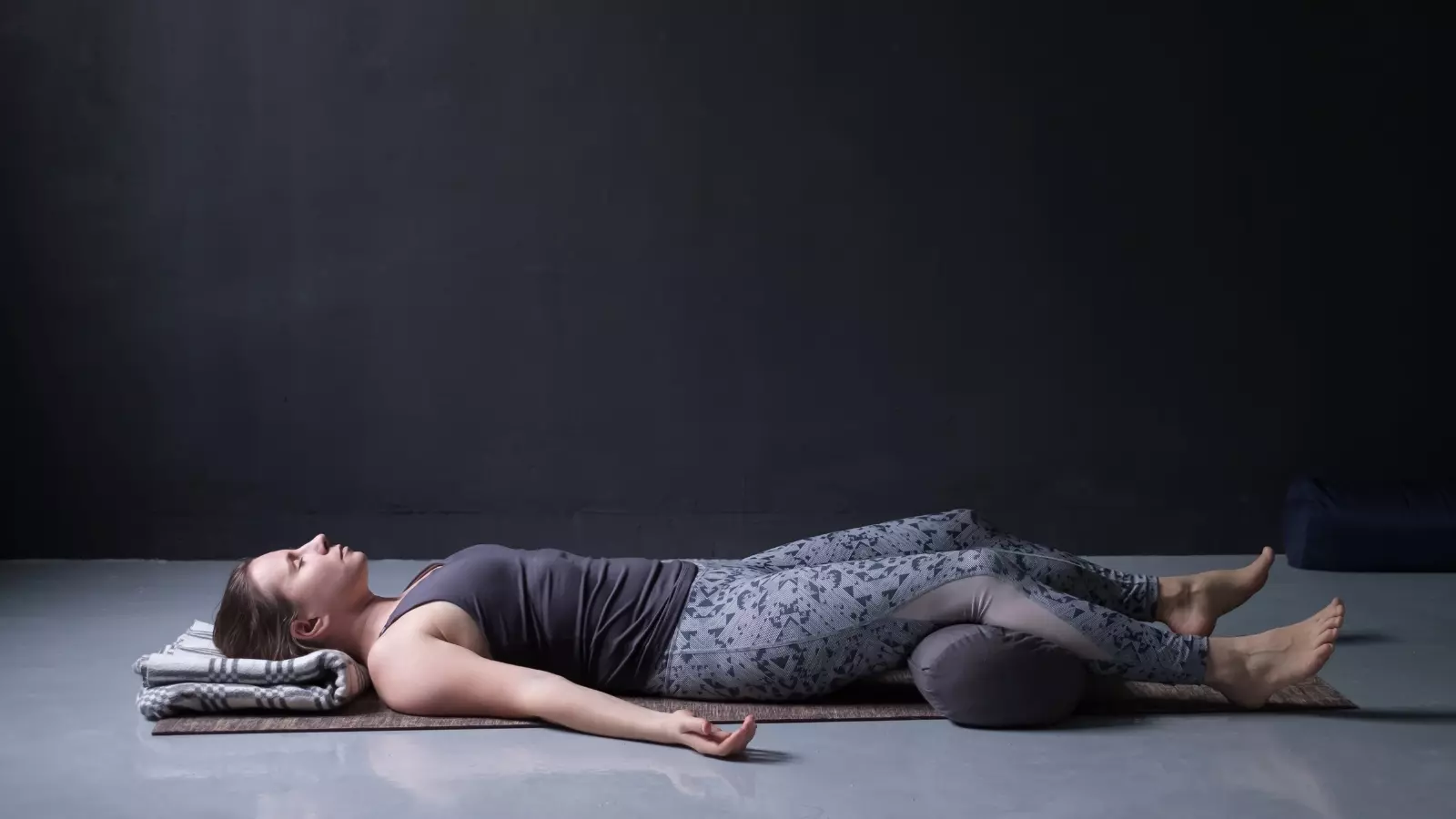 young woman practicing Savasana or Corpse Pose, resting after practice.