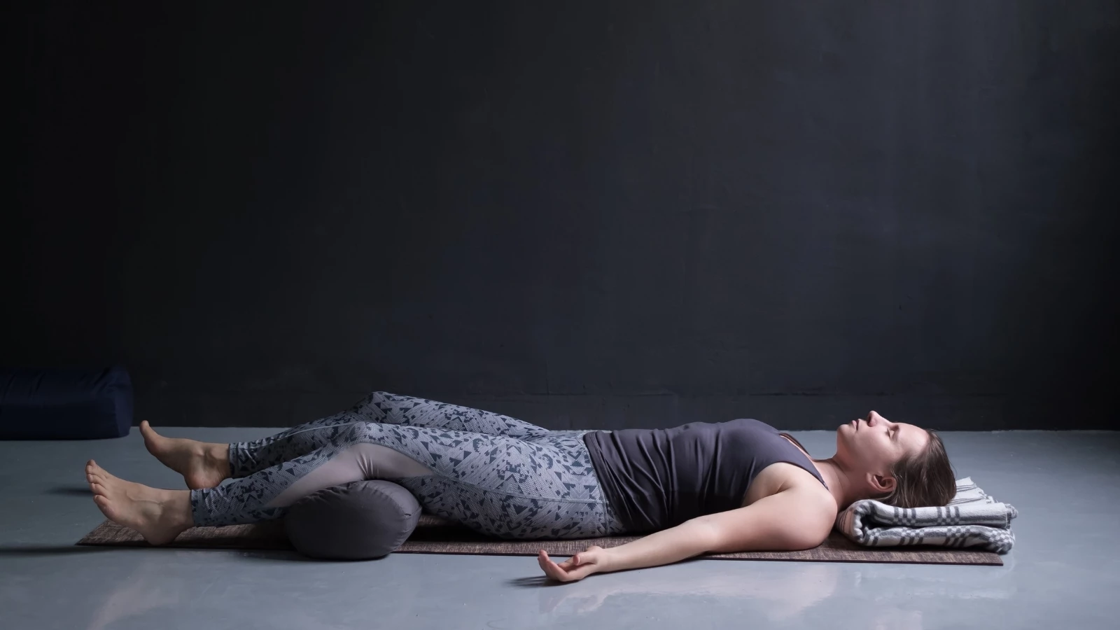 Young woman practicing yoga's Savasana Pose or Corpse Pose.