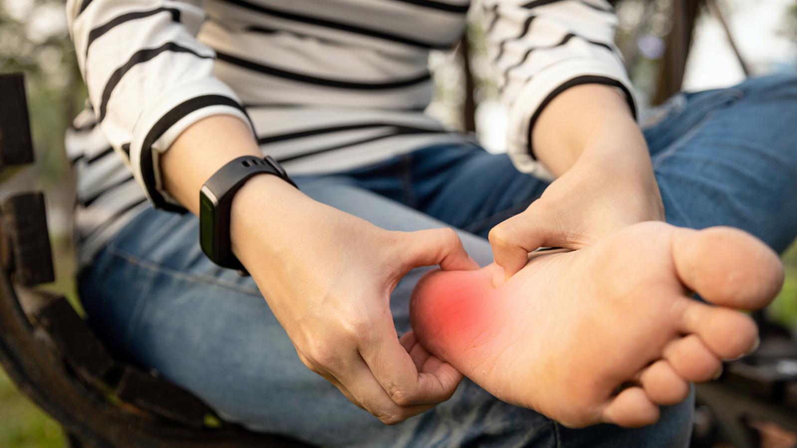 Plantar fasciitis, asian young woman holding her feet and massaging with her hand suffering from tendon inflammation. 