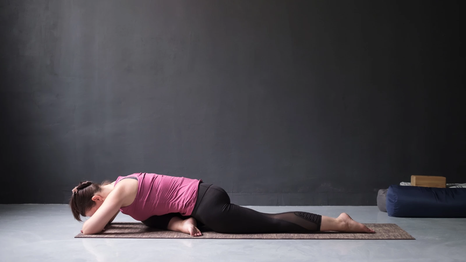 woman resting in forward folded One Legged King Pigeon Pose.