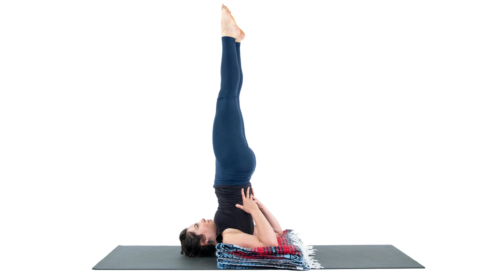 Student practicing Shoulderstand with the support of blankets.