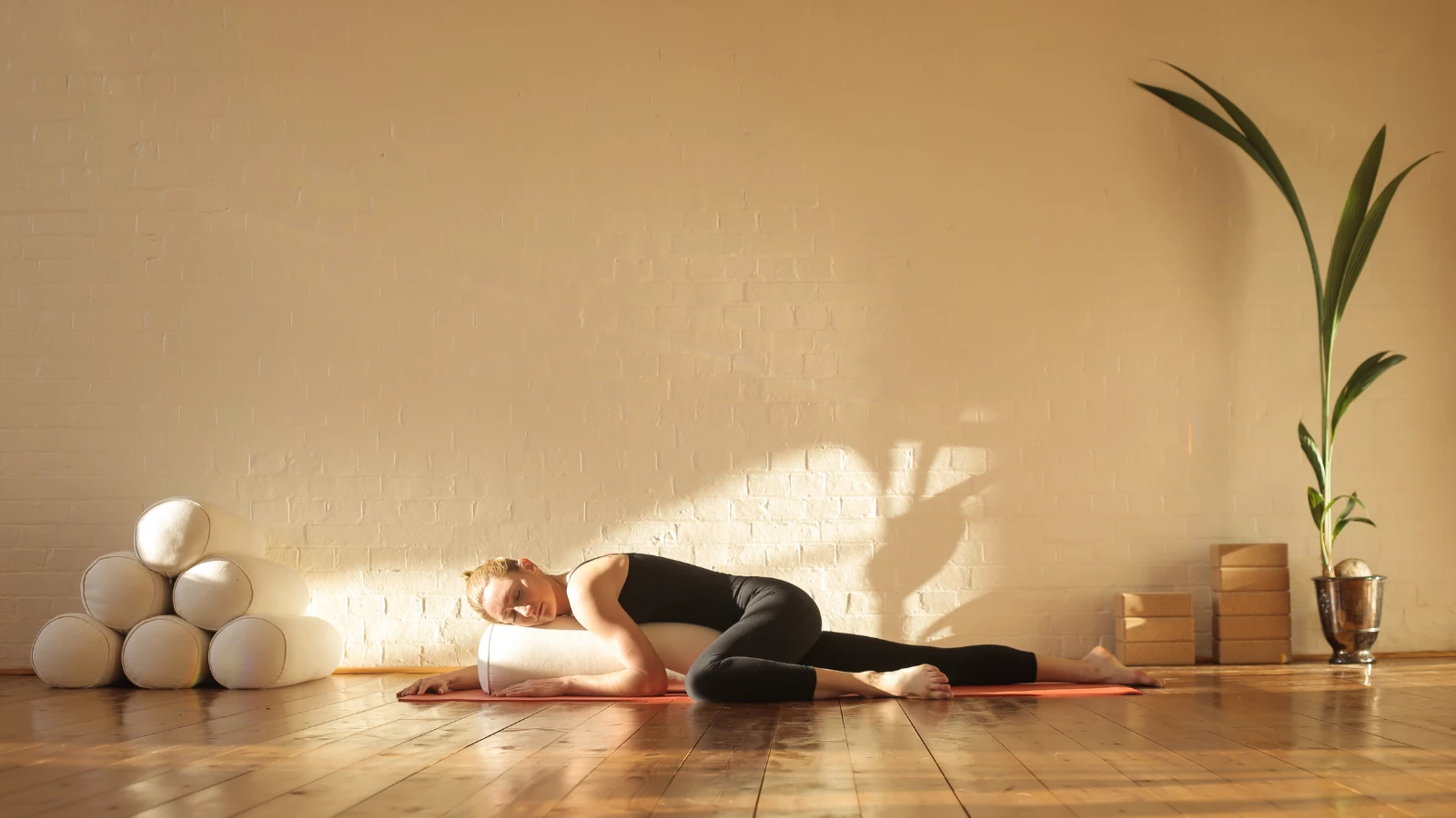 Woman practicing restorative yoga in a beautiful studio