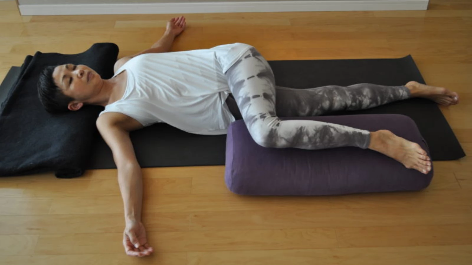 https://media.yogauonline.com/app/uploads/2022/05/06031852/How-to-practice-Supported-Supine-Twist-Jathara-Parivartanasana.-1.webp