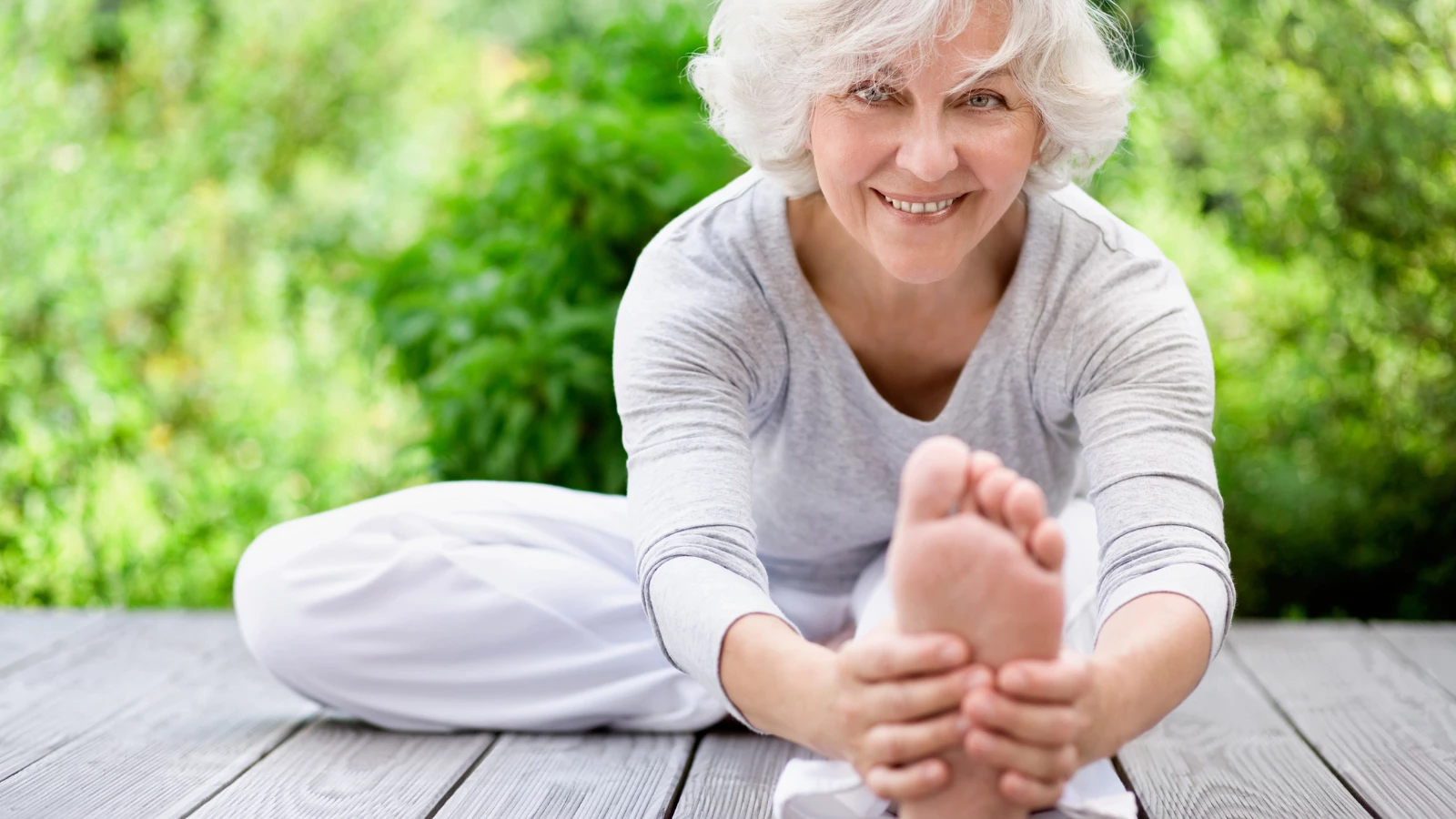 Mature woman practicing yoga stretches.