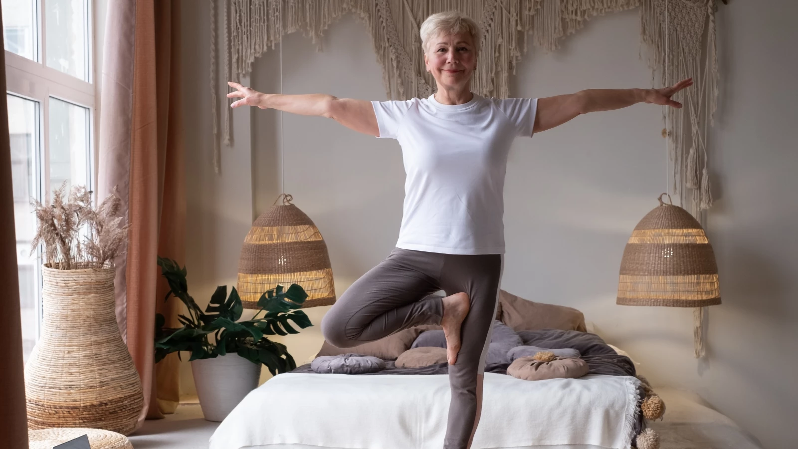 Full length portrait of senior woman in yoga pose Vrksasana, Tree Pose.