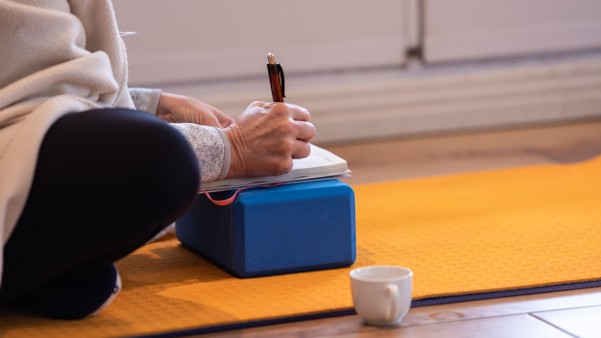 Side view of mature woman writing notes during the workshop in the yoga center to balance out too much yoga asana.