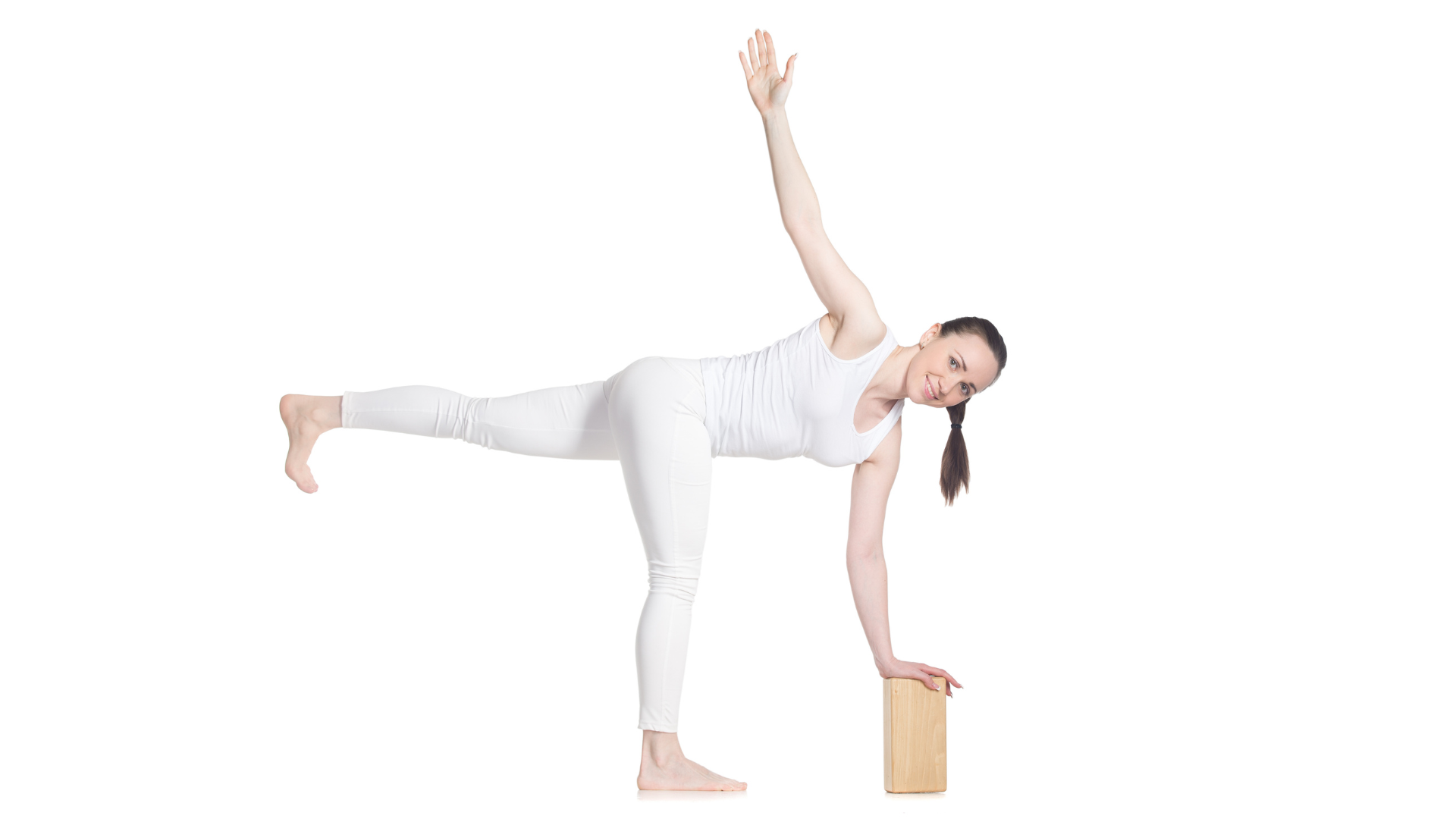 Sporty young cheerful yoga student practicing in Parivrtta Ardha Chandrasana (Revolved Half Moon) representing yoga as a way to manage holiday stress.