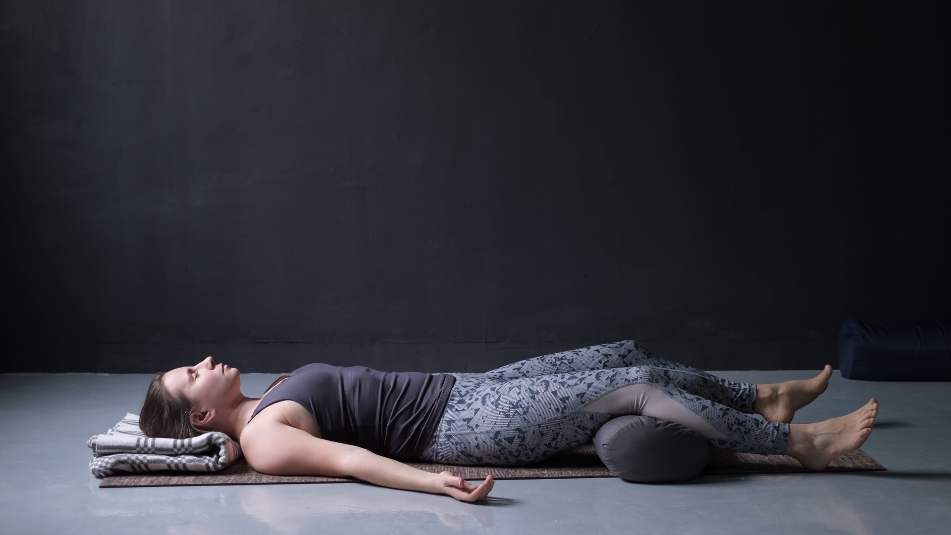 young woman practicing Savasana or Corpse Pose or resting after practice.