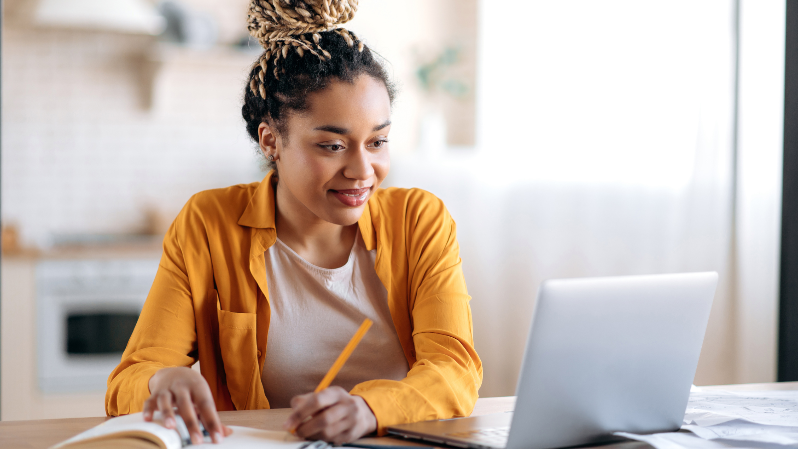 Focused African American female student studying online to improve her yoga teaching skills.