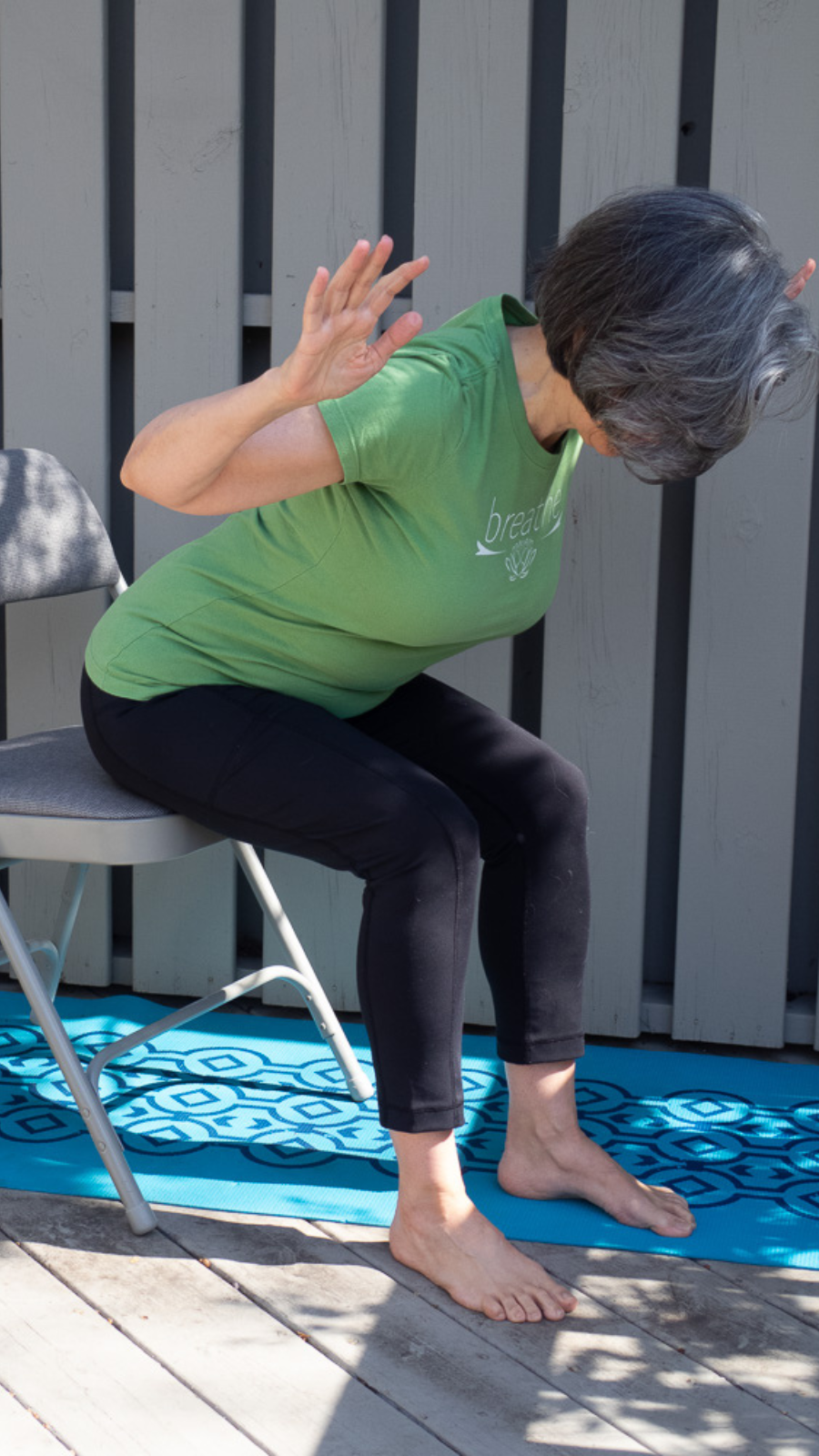 Practicing the yoga pose Ardha Uttanasana seated in a chair