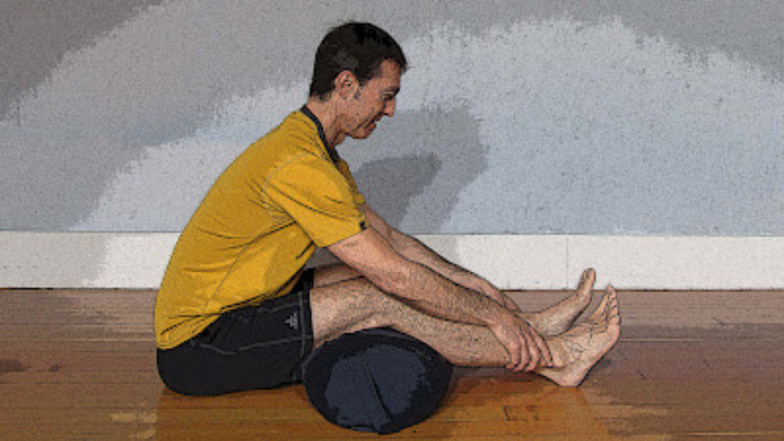 Paschimottanasana Pose or Seated Forward Bend Pose with a bolster under the knees for extra support