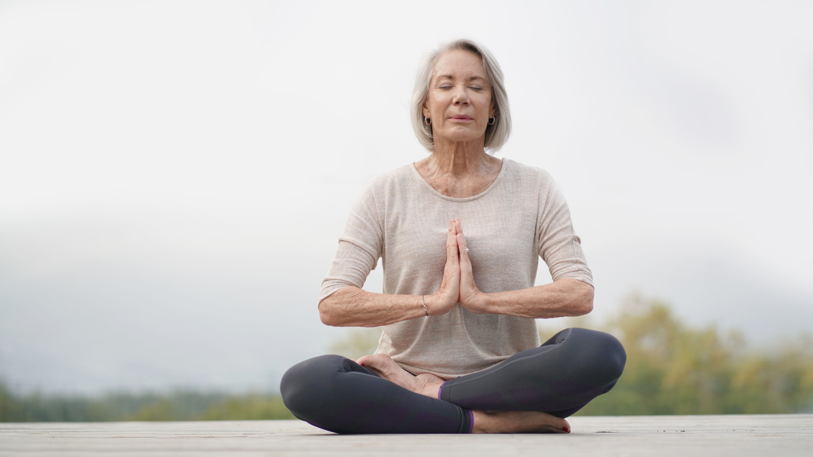 Serene senior woman meditating outdoors