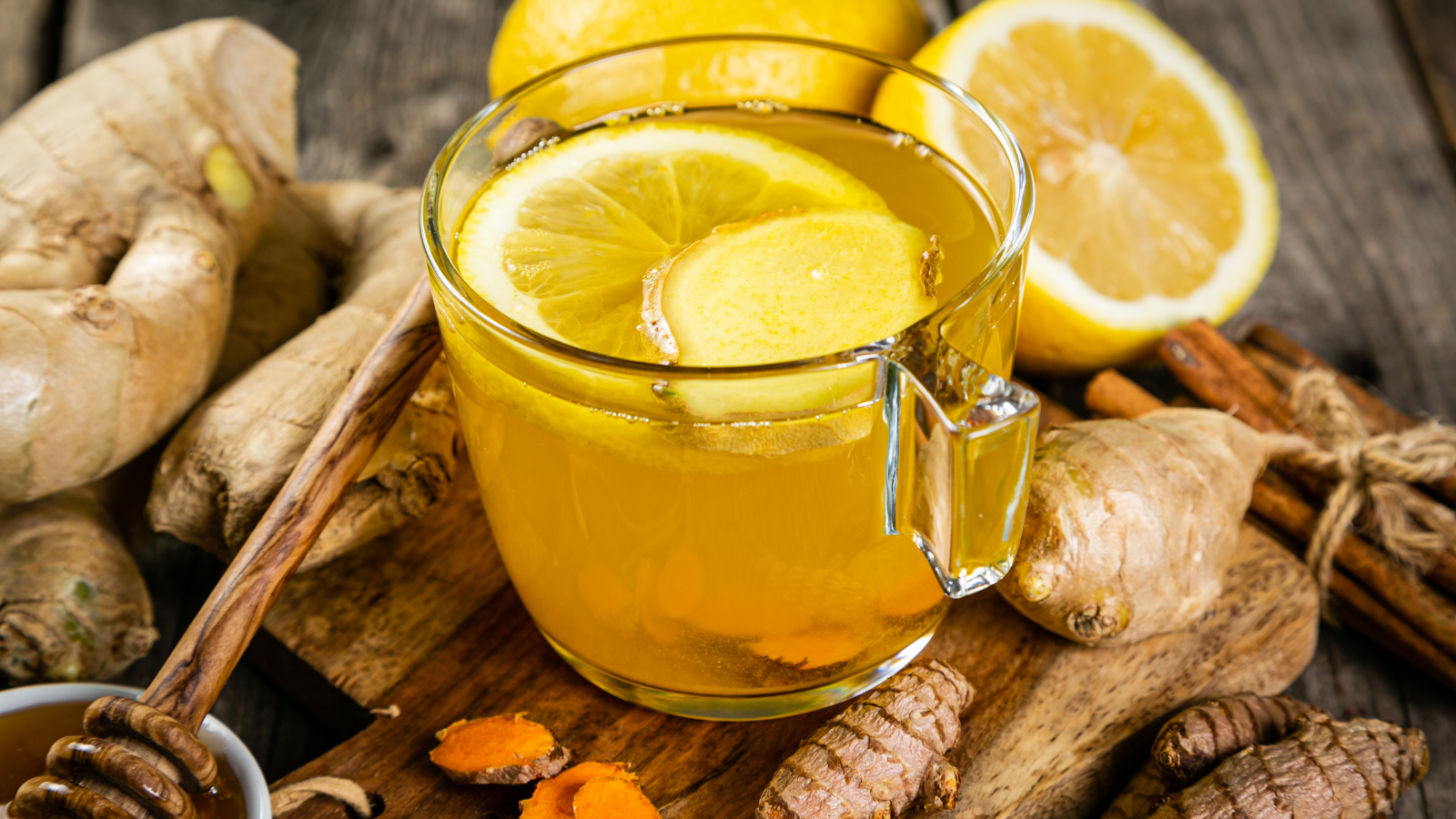 Fall immune system booster - ginger and turmeric tea and ingredients, rustic wood background