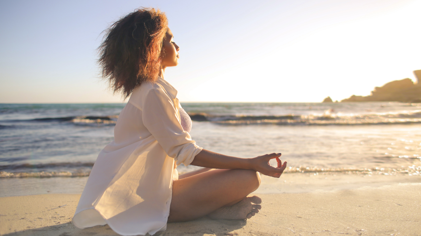 Woman sitting near the water in contemplation