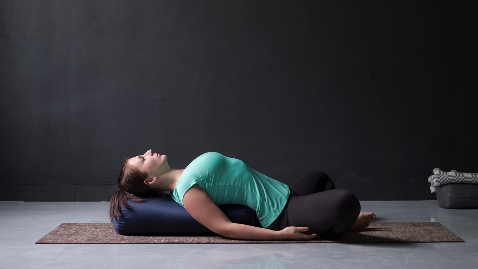  Woman in Reclined Butterfly Pose (Supta Baddha Konasana) to practice hip-opening yoga 