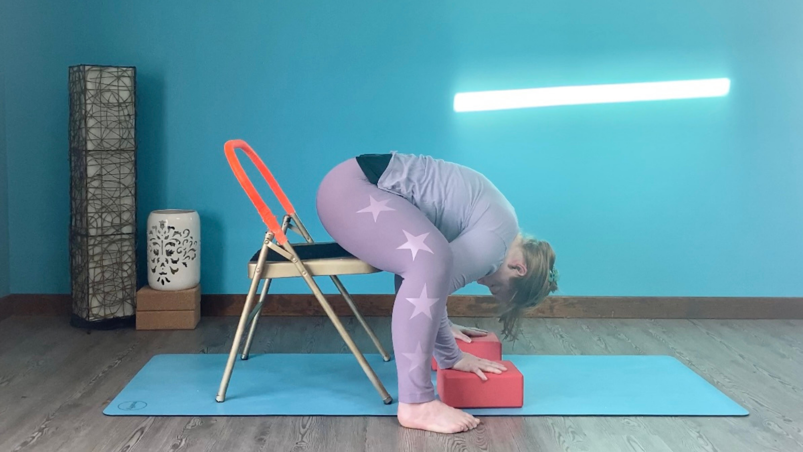 a seated version of Prasarita Padottanasana with the help of a chair and blocks.