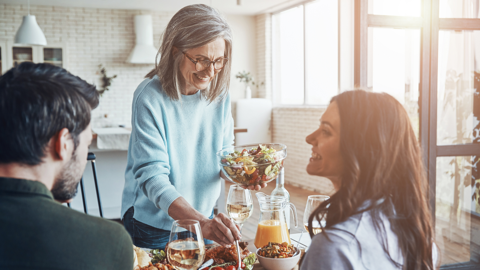 Senior woman serving a healthy dinner to her family.