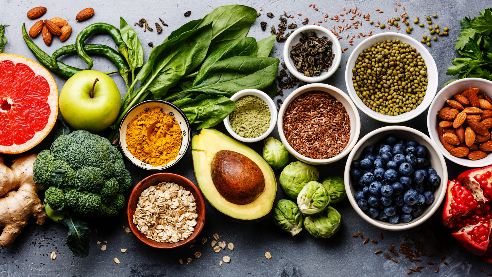 A display of healthy foods, including fruits, vegetables, grains, and leafy greens. 