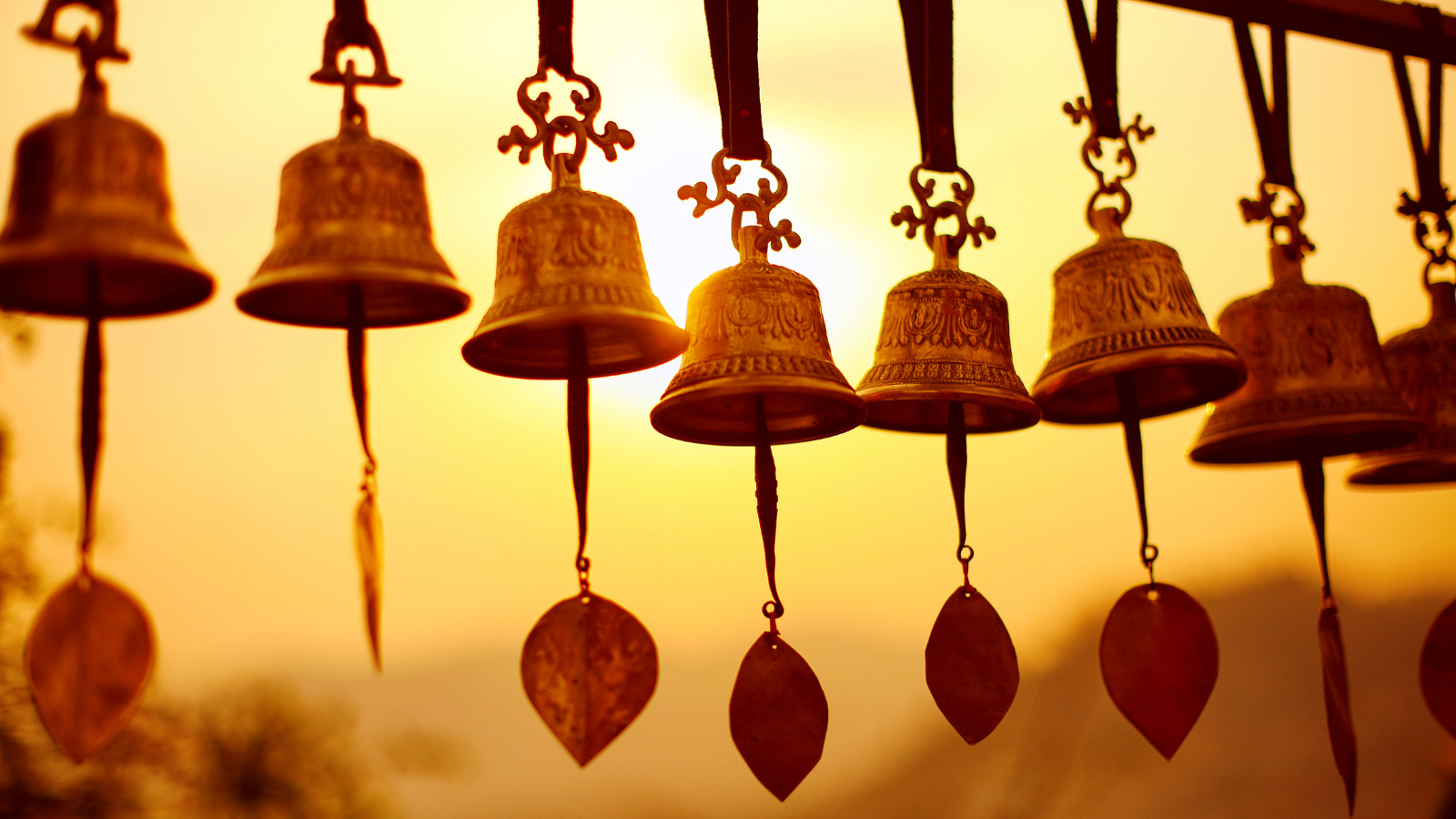 Nepalese traditional bells over the sun at sunset. 