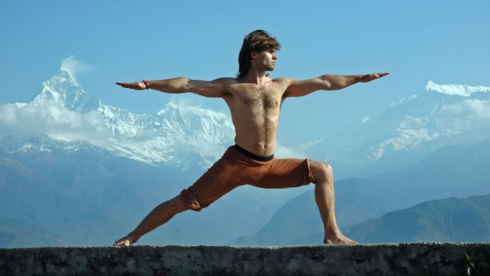 Image also depicts how to differentiate between movements and actions (more subtle) in yoga practice. Image depicts Warrior ll pose or Virabhadrasana Pose practiced in a mountain setting.