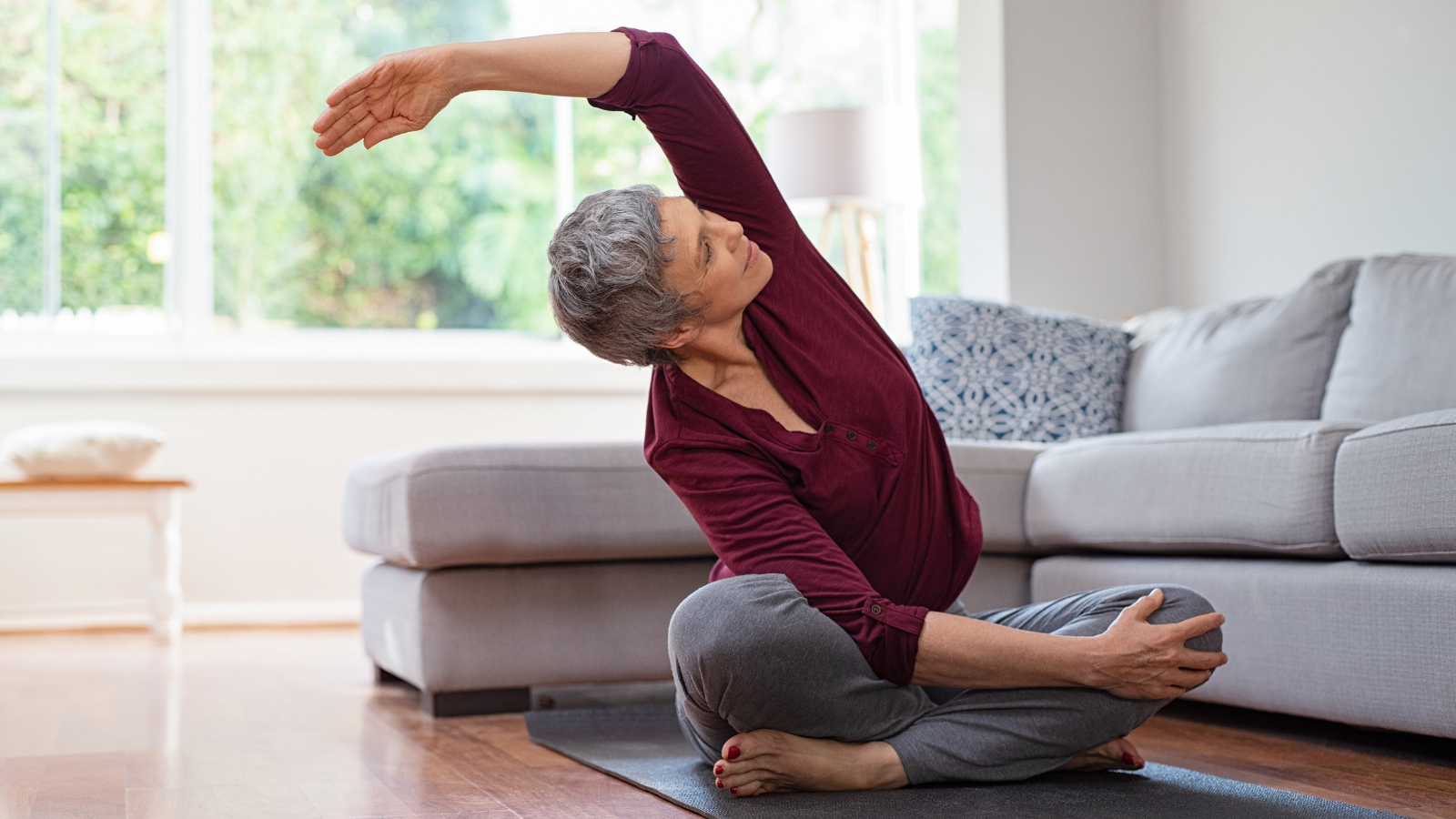 Senior woman exercising while sitting in lotus position.