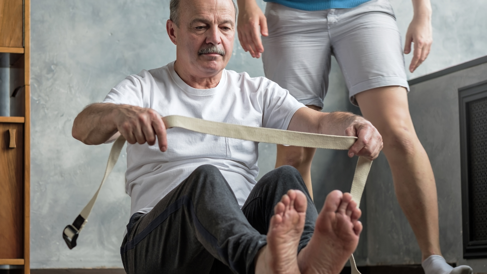 Senior hispanic man doing yoga at home with his yoga teacher.