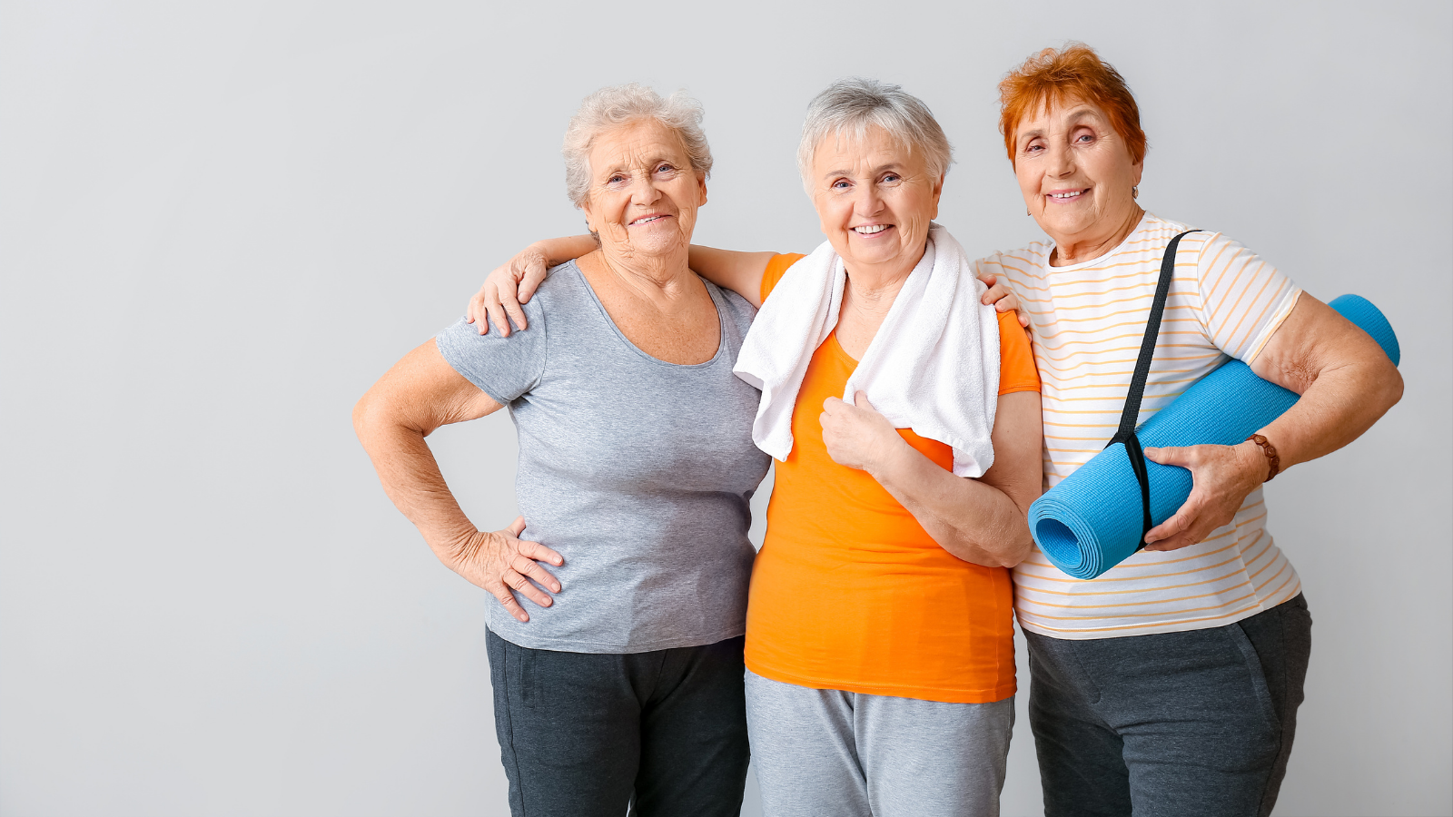 Happy elderly women with yoga mat on light background.