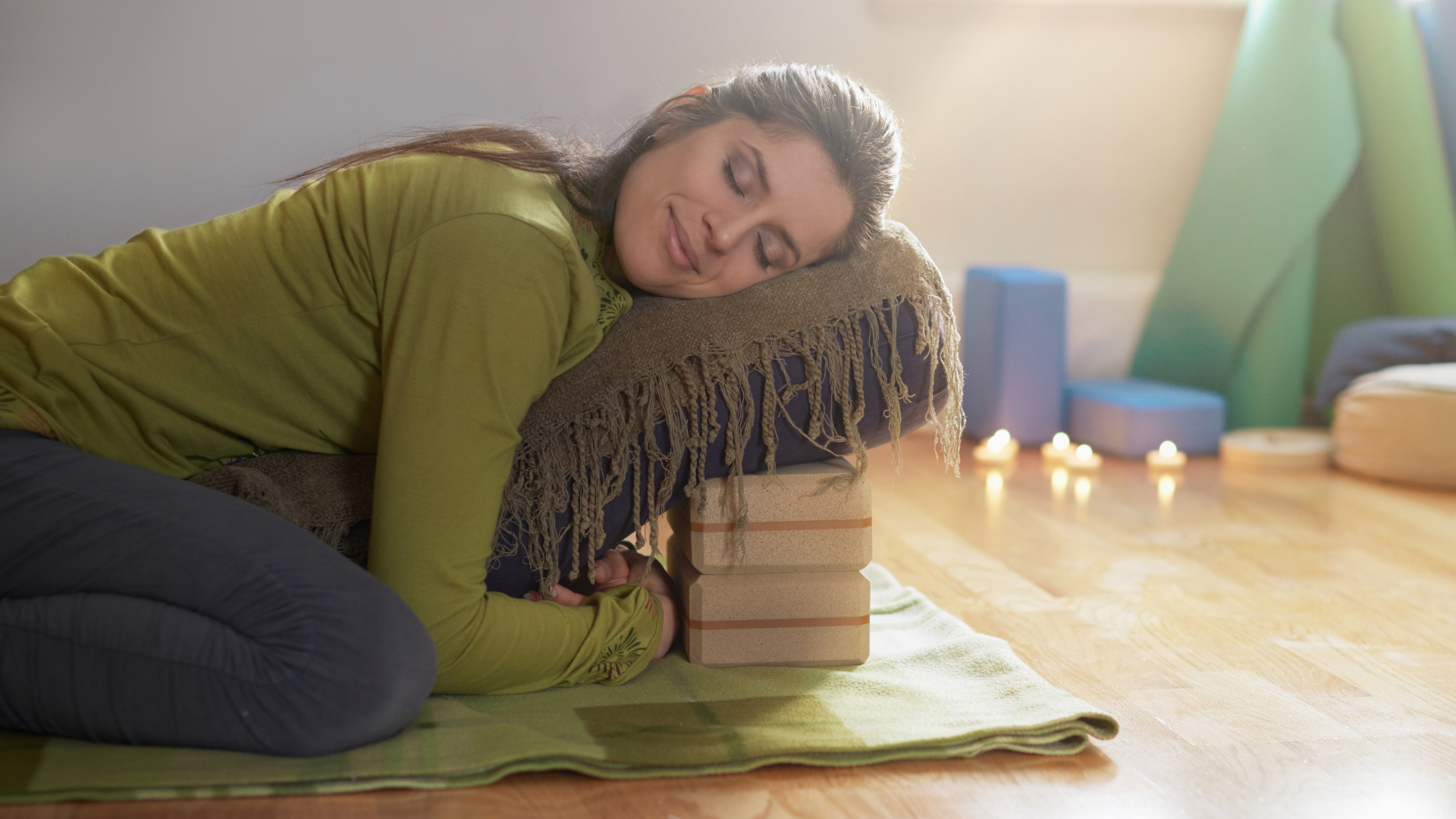 Serene lady relaxing and meditating on a yoga mat in a cozy house.