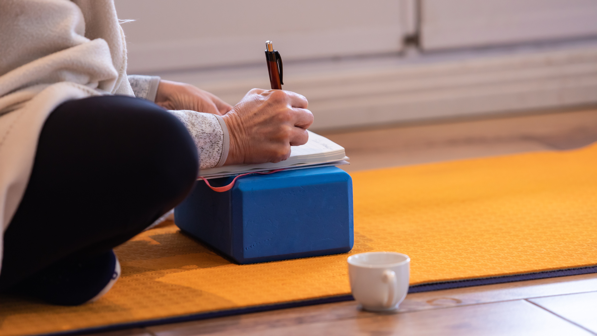 Mature woman writing notes about her practice. 