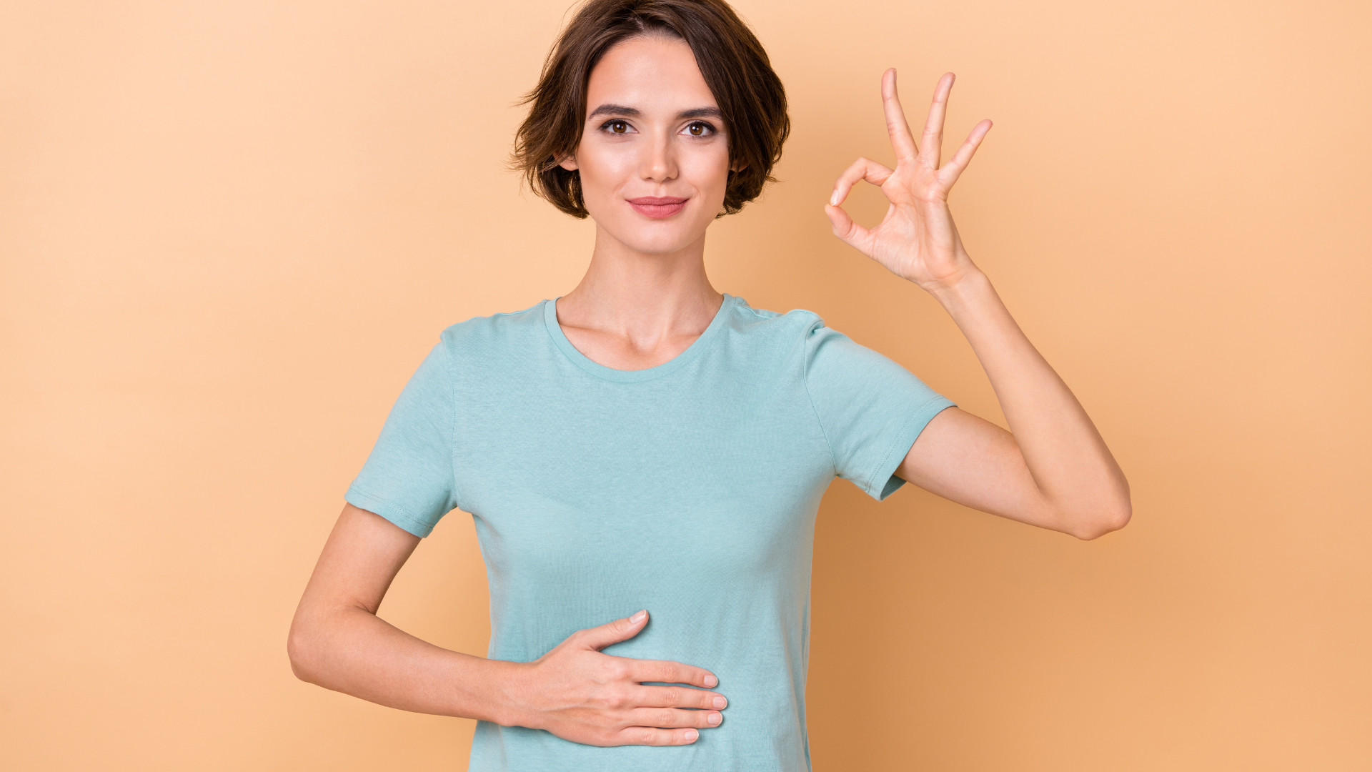 Photo of young lady arm on belly show fingers OK symbol good for a happy healthy gut.